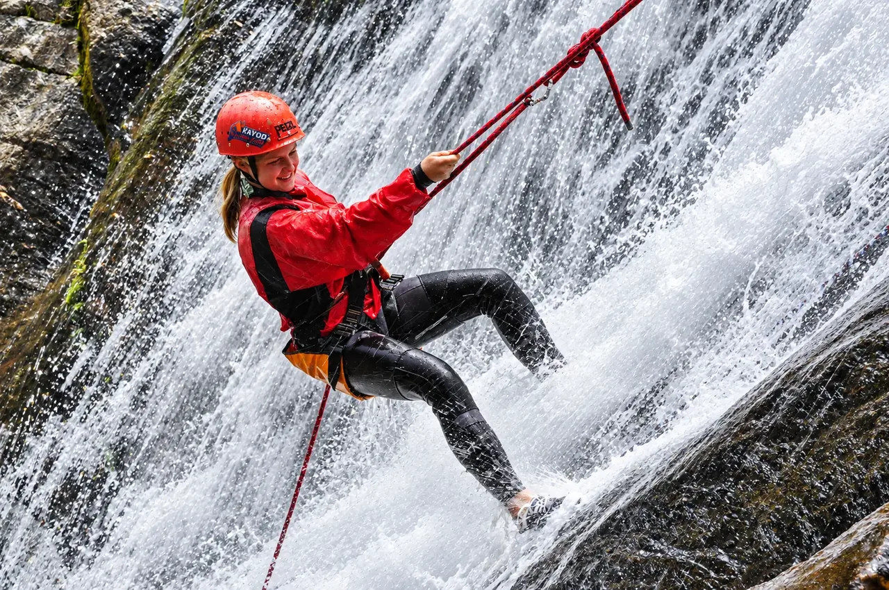 Persona practicando canyoning en una cascada de Baños, Ecuador